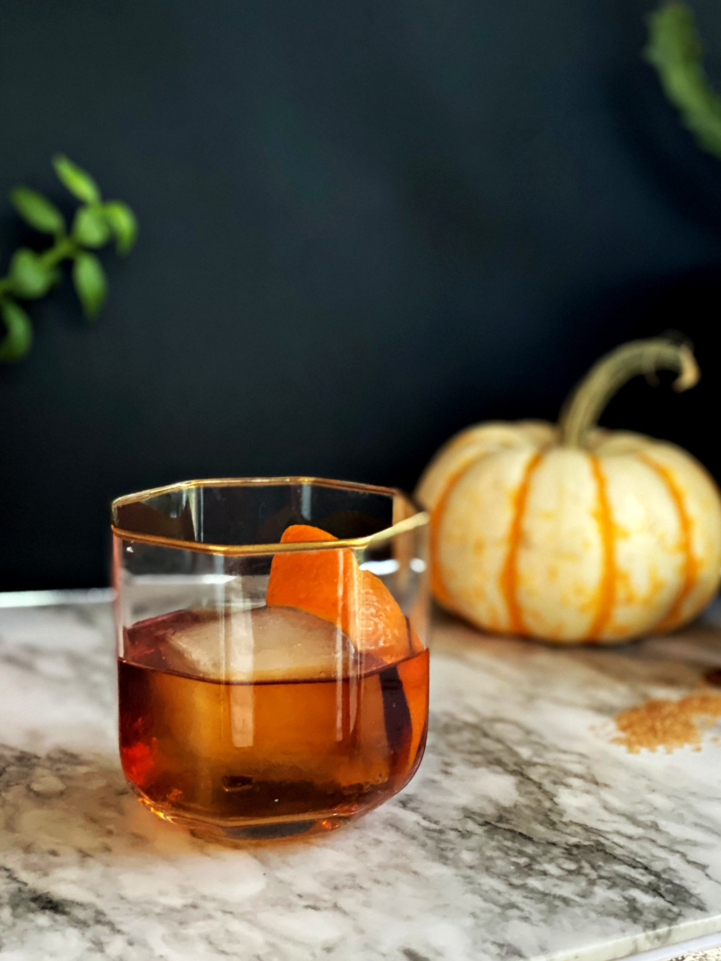 A Rum Old Fashioned cocktail in a rocks glass with an orange peel garnish.