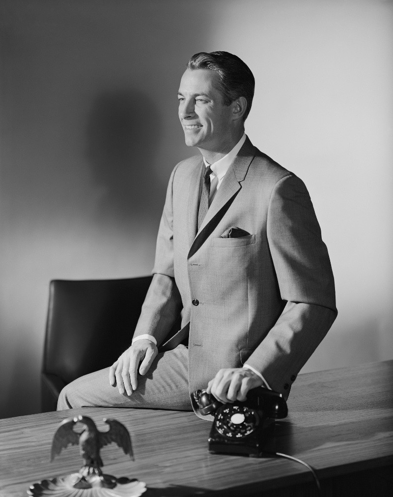 1960s businessman in a gray suit, showcasing Mad Men fashion.