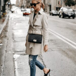 Woman wearing a trench coat, jeans, and loafers