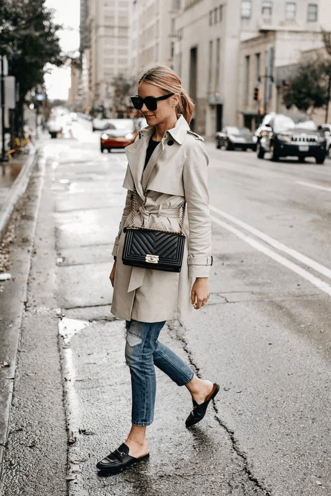 Woman wearing a trench coat, jeans, and loafers