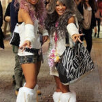 A group of young women showcasing vibrant gyaru fashion in an urban setting, highlighting their tanned skin, blonde hairstyles, and bold makeup, embodying the energetic and rebellious spirit of Japanese youth culture.