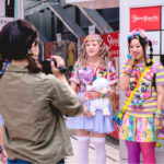 Three girls in Decora fashion being interviewed by two people in front of a Harajuku building