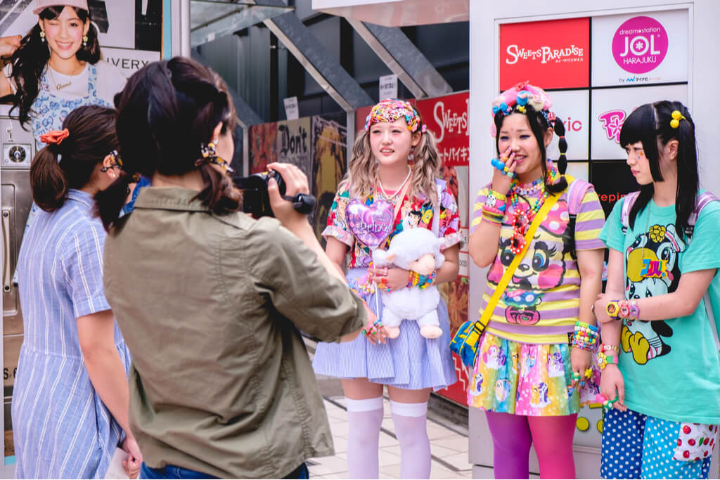 Three girls in Decora fashion being interviewed by two people in front of a Harajuku building