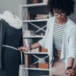 A fashion designer sketching a design in a notebook.