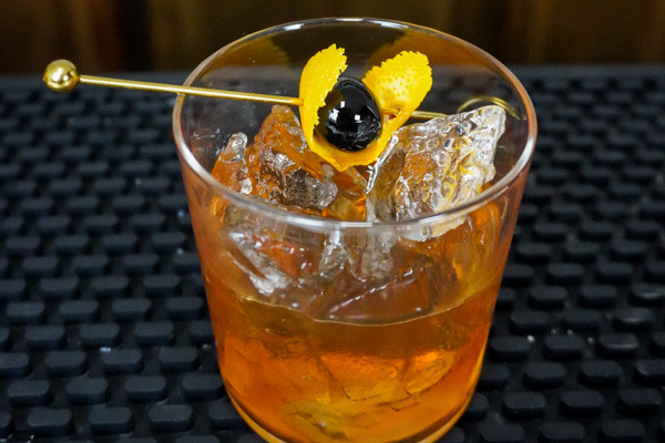 An Old Fashioned cocktail made with Bulleit Rye, garnished with an orange peel.