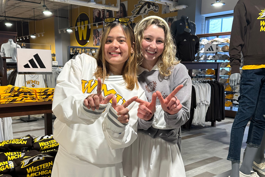 Two students showcasing their winning designs for the NYFW competition.