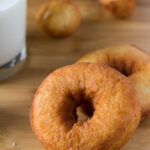 Golden brown old-fashioned cake donuts with a dusting of powdered sugar.