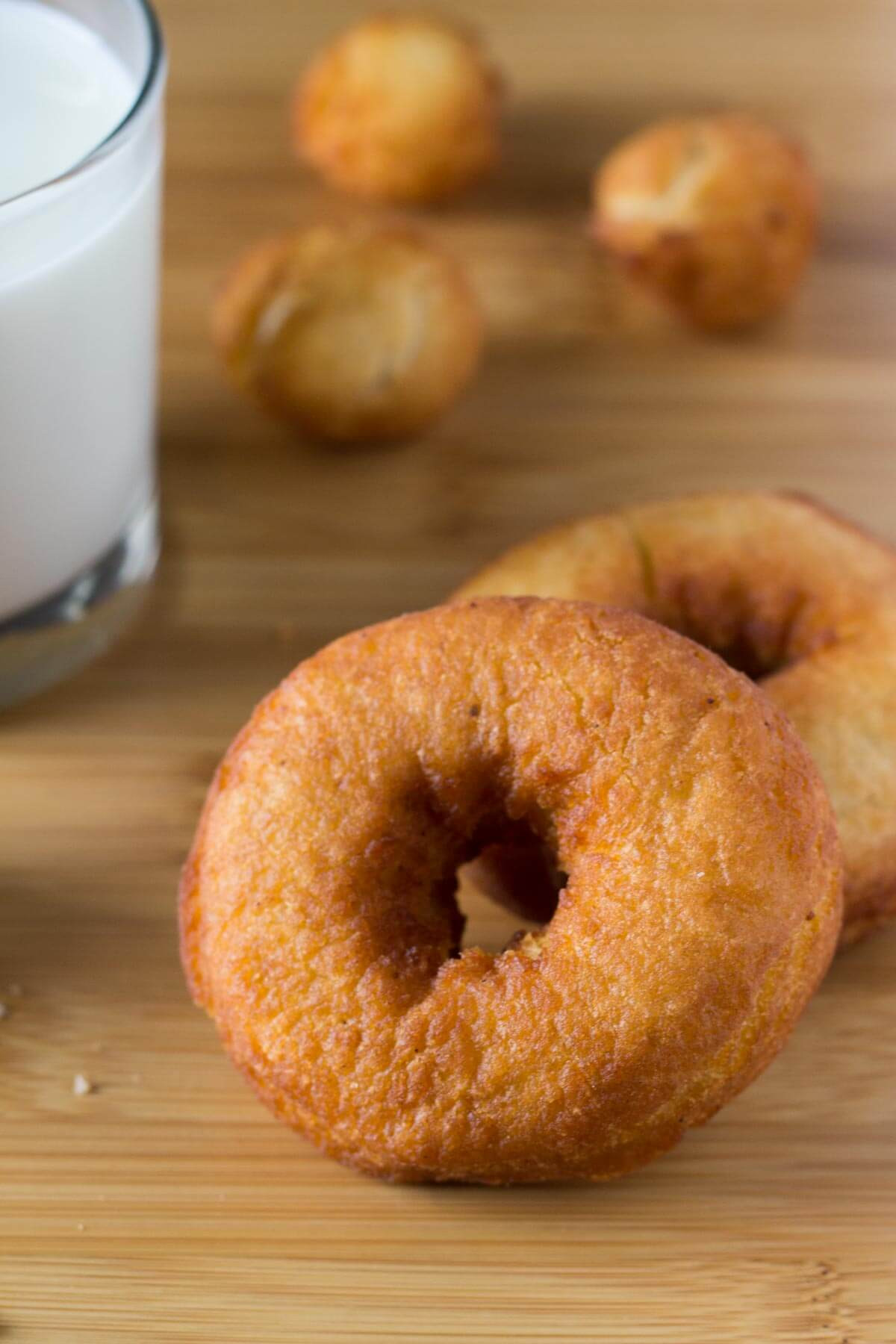 Golden brown old-fashioned cake donuts with a dusting of powdered sugar.