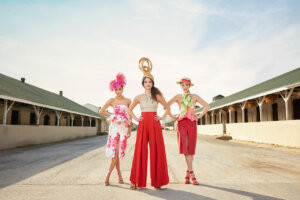 alt text: Woman in a pink dress and large white hat at the Kentucky Derby