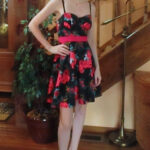 A short black dress with a red floral print is shown before any alterations.