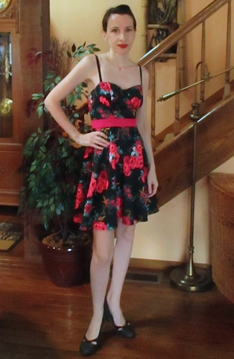 A short black dress with a red floral print is shown before any alterations.