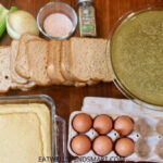 celery, onion, salt, sage, broth, bread, cornbread, and eggs on a wooden board