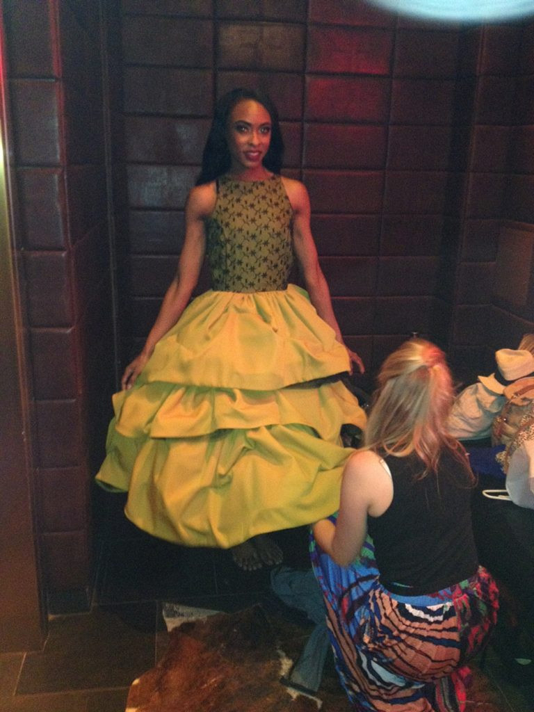 A model wearing a mustard yellow dress with a black lace bodice at Las Vegas Fashion Week.