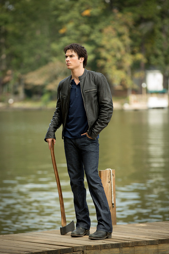 Damon Salvatore leaning against a classic car, showcasing his signature leather jacket and brooding demeanor.