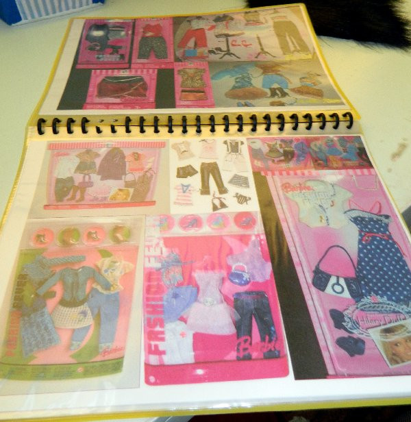 Two pages from a homemade Barbie fashion guide book, showcasing meticulously arranged Fashion Fever outfits and accessories. Each item is neatly placed within designated boxes, highlighting the collector's dedication to organization and documentation. Keywords: Barbie Fashion Fever, doll clothes organization, fashion doll collecting, homemade guide, doll outfit catalog, collector resource, fashion fever archive, visual guide, doll fashion history, Barbie accessories.