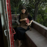 alt text: Woman in a long dress and vest at a flea market in Mexico City.