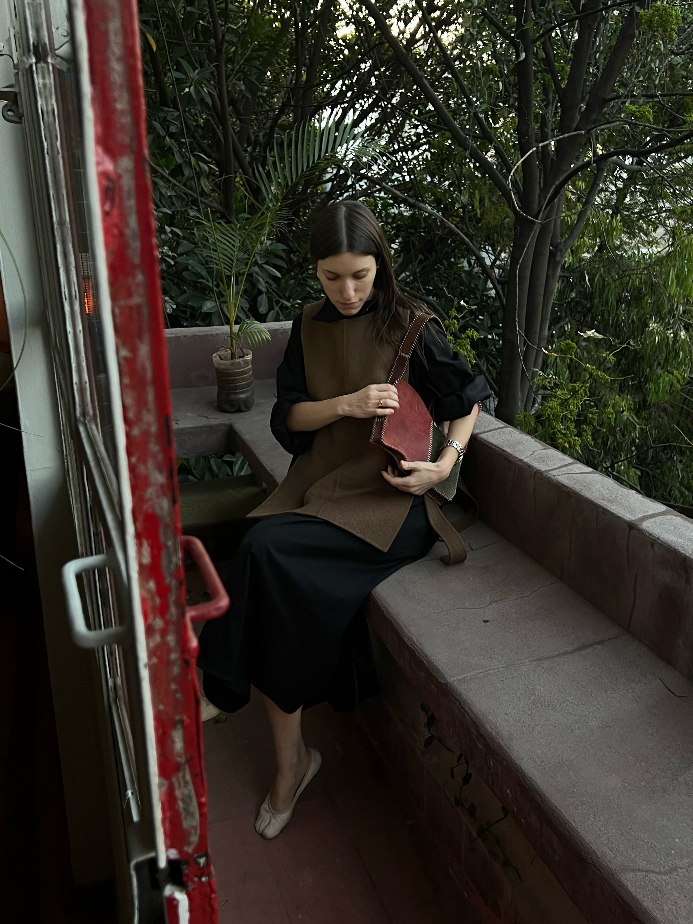 alt text: Woman in a long dress and vest at a flea market in Mexico City.