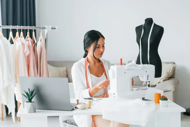 Fashion design student expertly using a sewing machine in a studio