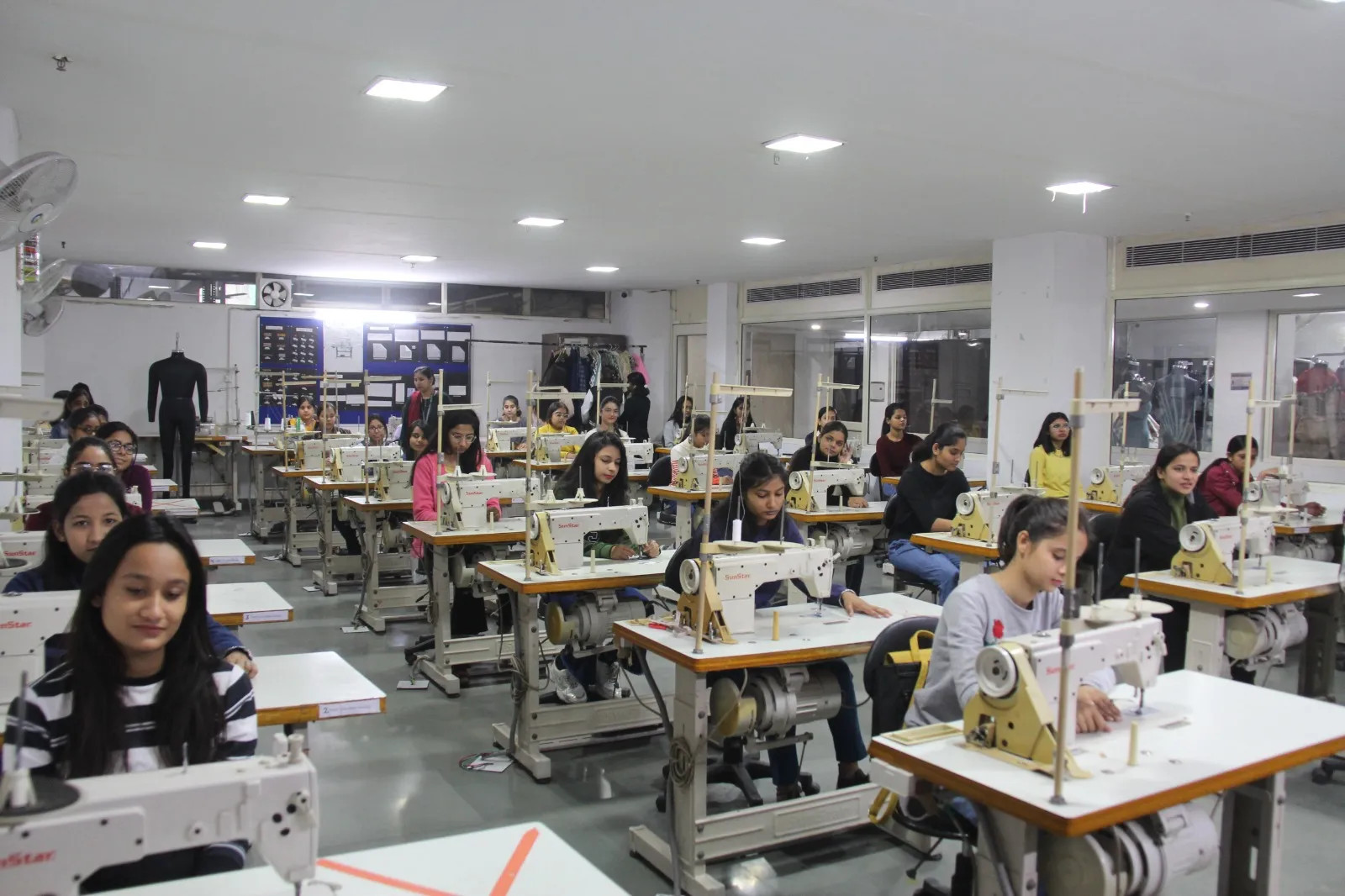 Student at MIT ADT University, Pune, working on a sewing machine, highlighting the technology-focused fashion design education in Indian colleges.