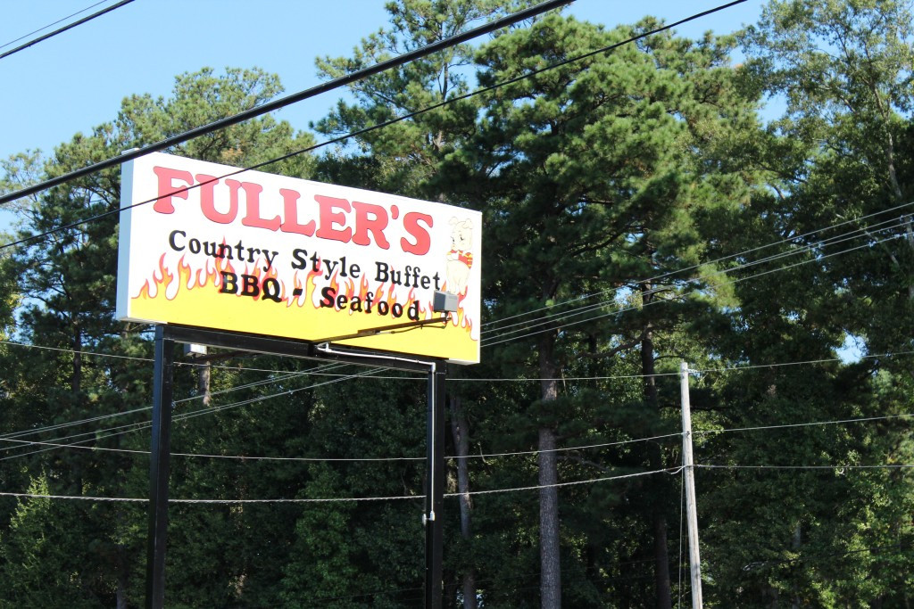 Fuller's Old Fashion BBQ restaurant exterior in Lumberton NC, showcasing its large log cabin style building and prominent signage.