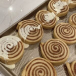 Close-up of frosted cinnamon rolls in a baking dish.