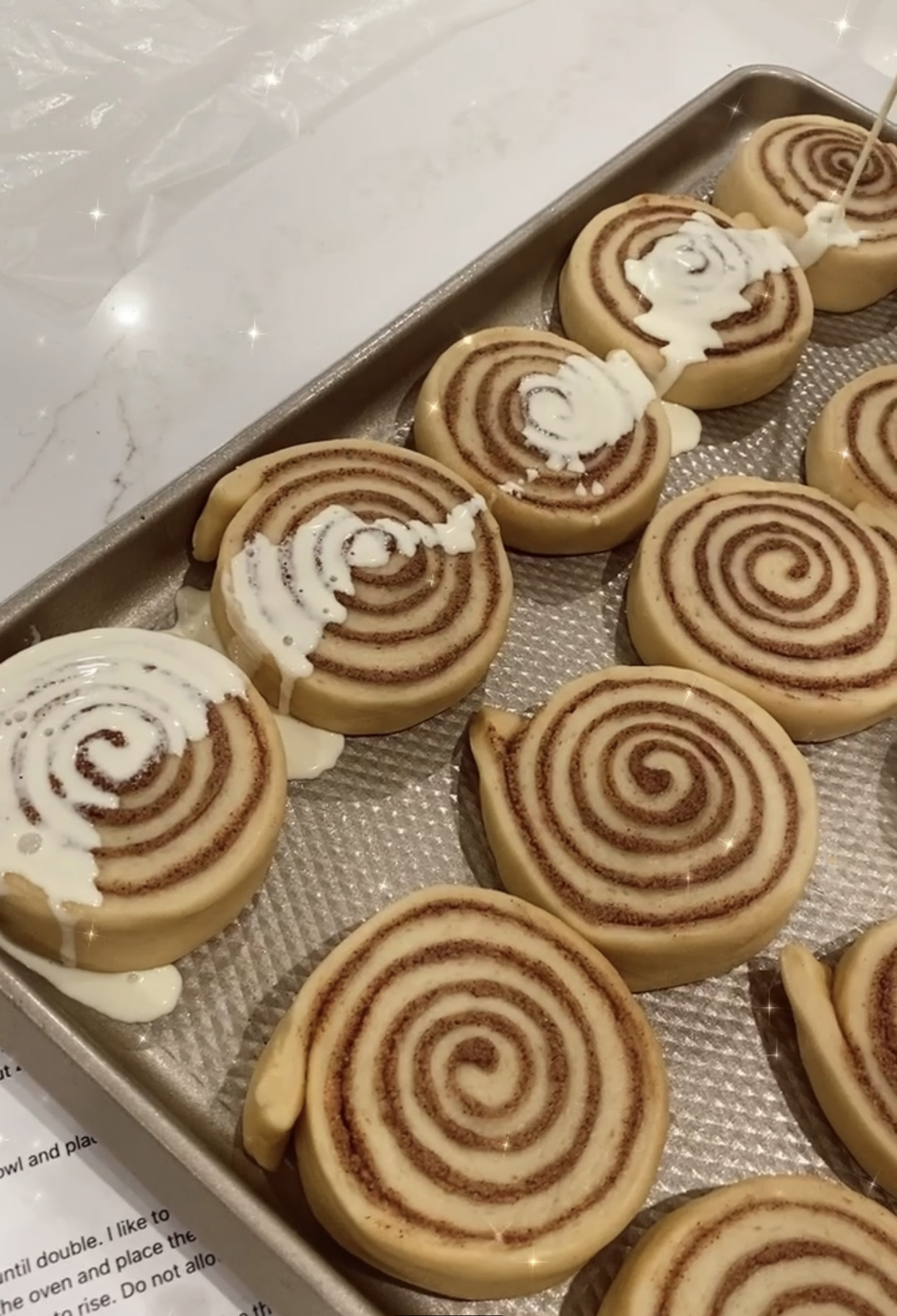 Close-up of frosted cinnamon rolls in a baking dish.