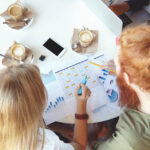 A group of people sitting around a table looking at innovative graphs.