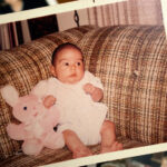 A Polaroid of a baby holding a stuffed animal