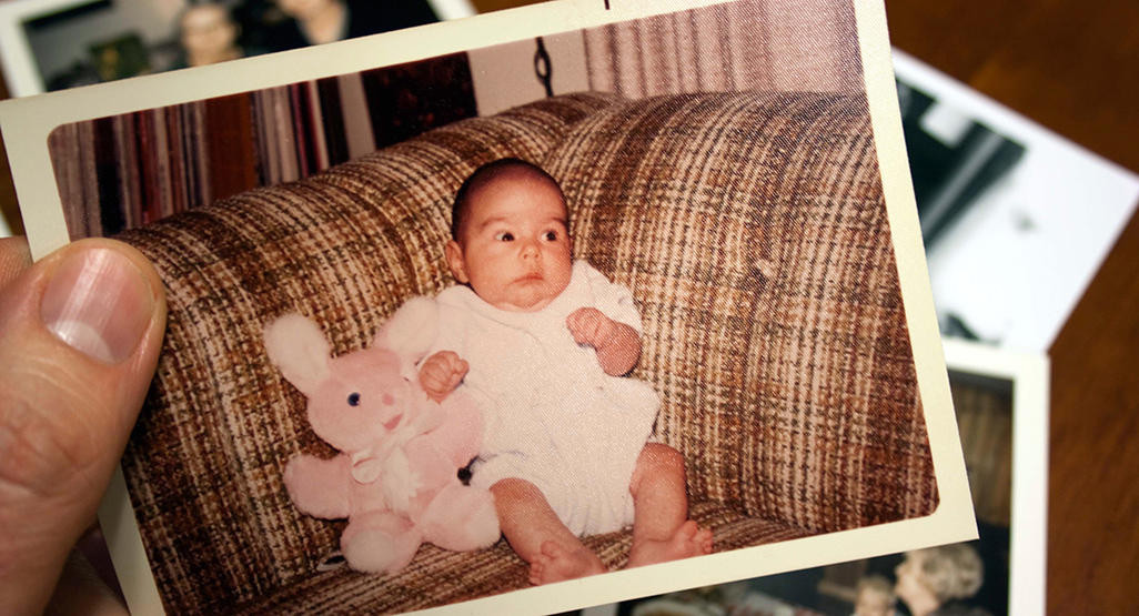 A Polaroid of a baby holding a stuffed animal