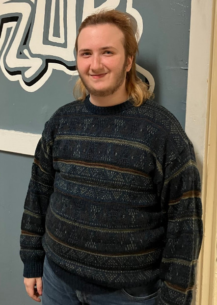 University of Rochester student Jay Kinde posing in a thrifted outfit