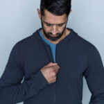 Tall man in blue hoodie layering for style and warmth.