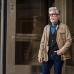 Man in a cardigan under a field jacket, showcasing a classic old man fashion style.