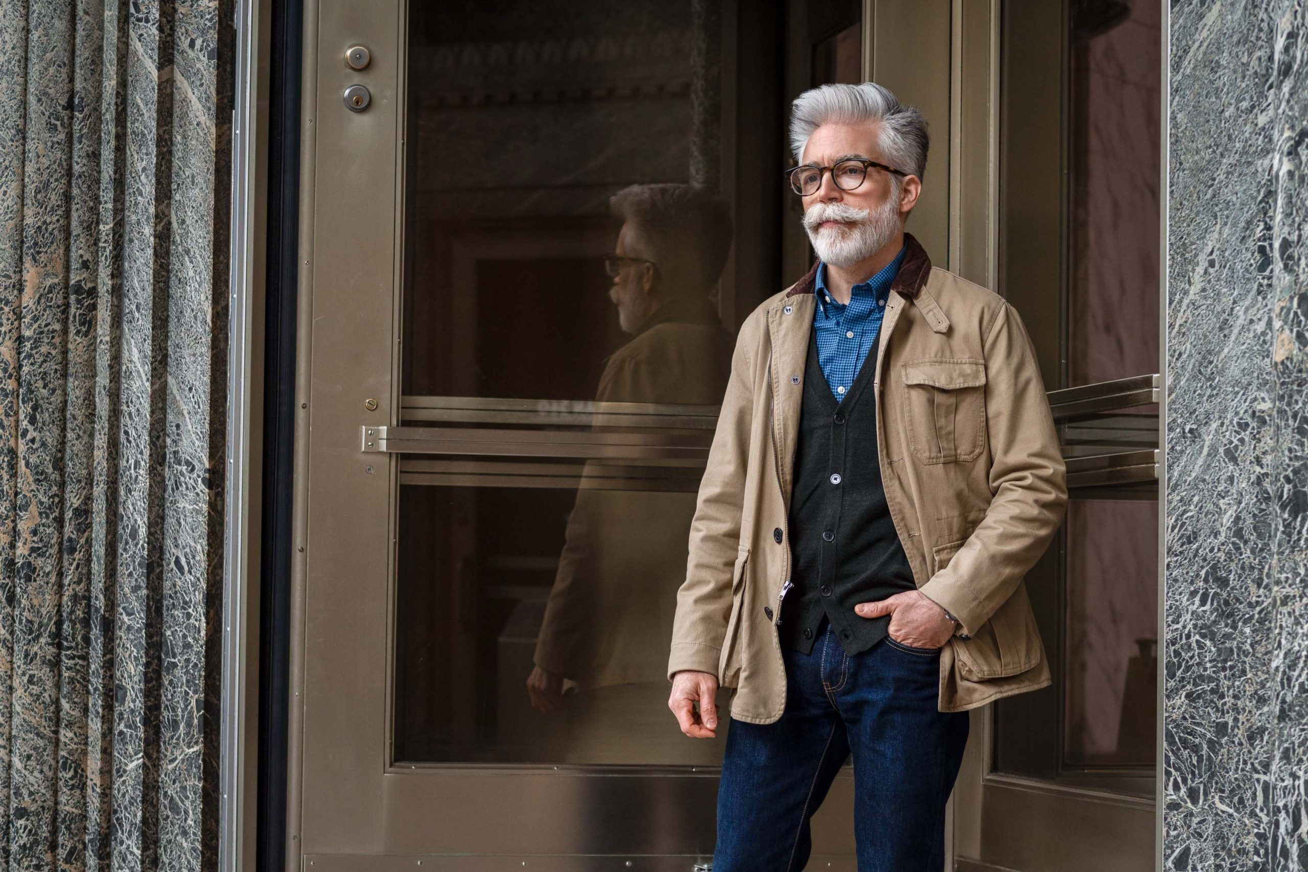 Man in a cardigan under a field jacket, showcasing a classic old man fashion style.