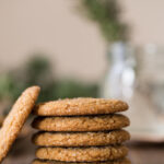 Five Old Fashioned Ginger Snaps stacked on top of each other, with one Old Fashioned Ginger Snap leaning against the stack.