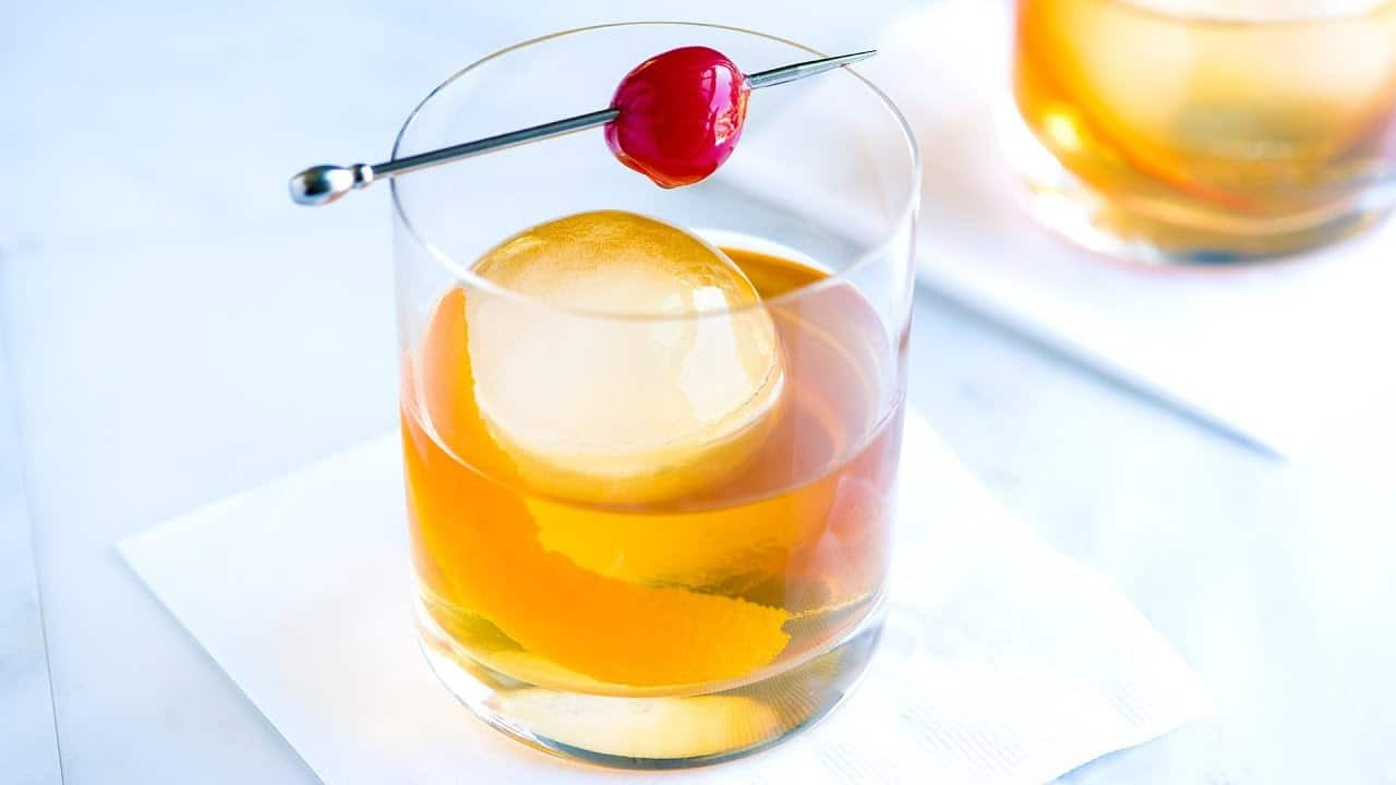 Old Fashioned cocktail ingredients being combined in a glass