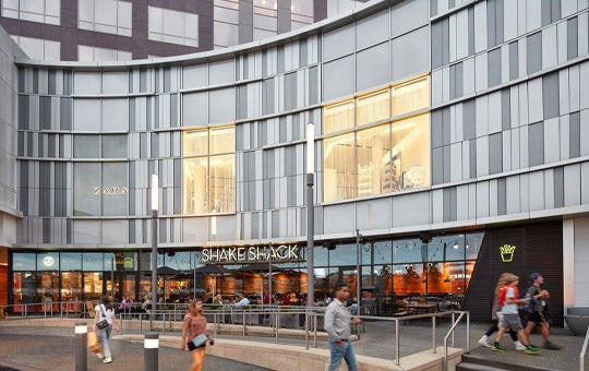 Exterior view of Fashion Centre at Pentagon City, showcasing its modern architecture and inviting entrance, perfect for shopping in Arlington VA.