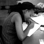 Irene Muthami sketching fashion designs, showcasing her formative stage and skill development.