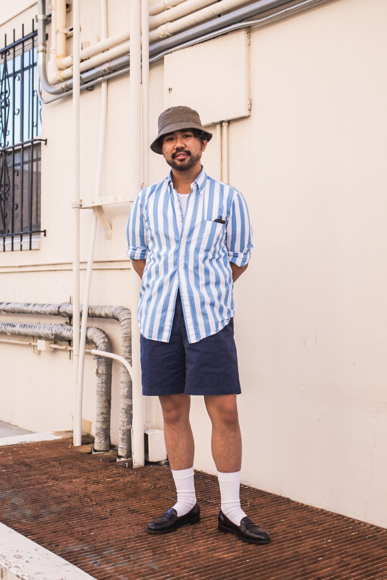 Man wearing a button down shirt, shorts, loafers, and patterned socks for a relaxed smart casual summer style