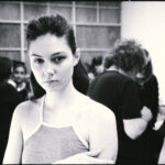 Backstage view of a model getting final touches of makeup before a London Fashion Week 2023 show, capturing the pre-show atmosphere and meticulous preparation.