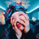 alt text: TAEMIN in a spike-gathered tartan wool set by Charles Jeffrey Loverboy in his 'Advice' MV.