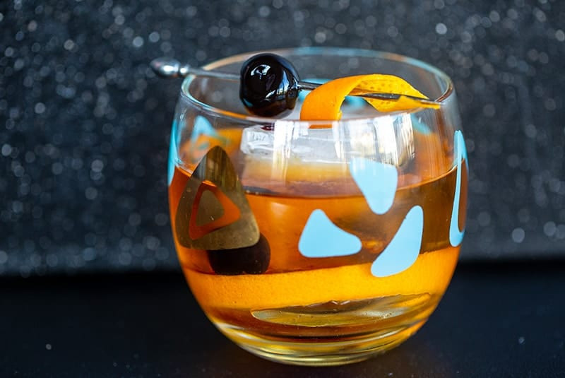 Old Fashioned cocktail in an old fashioned glass garnish with cherry and orange