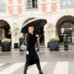 Stylish woman in a black sweater dress and combat boots in Paris during fall.