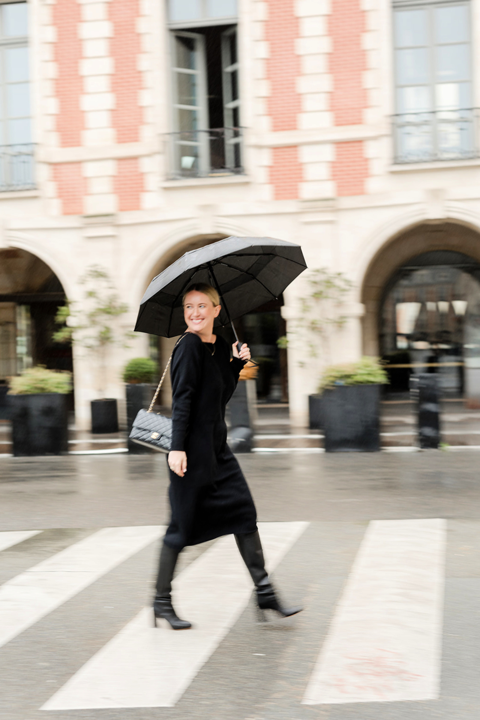 Stylish woman in a black sweater dress and combat boots in Paris during fall.