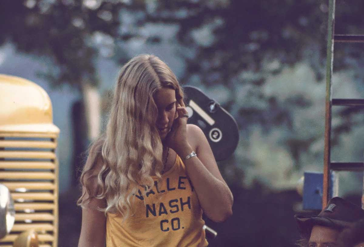 alt text: A man at Woodstock wearing a fringed suede vest and jeans.