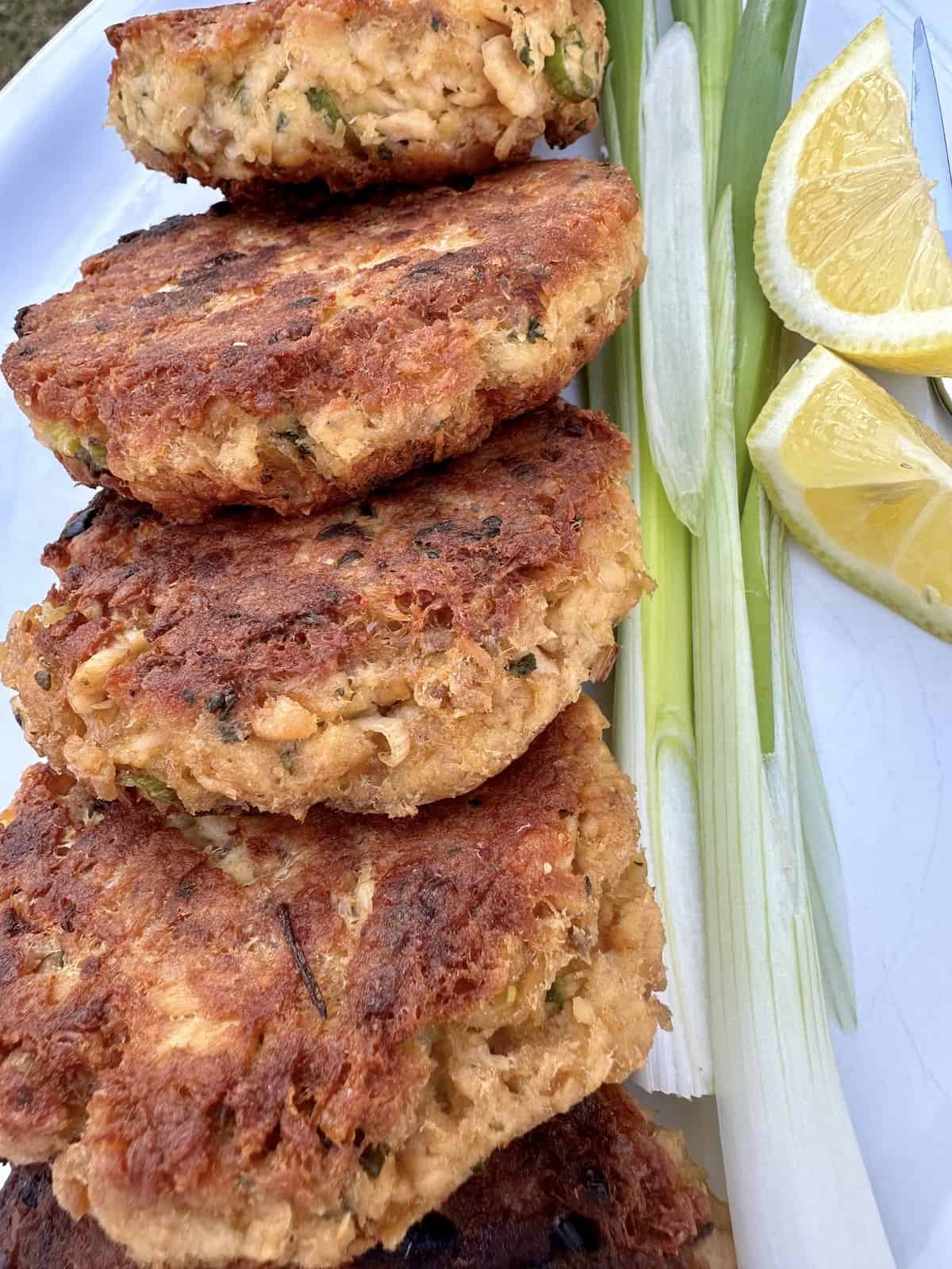 Old Fashioned Salmon Patties on a plate with garnishes, showcasing their golden-brown crust and inviting texture