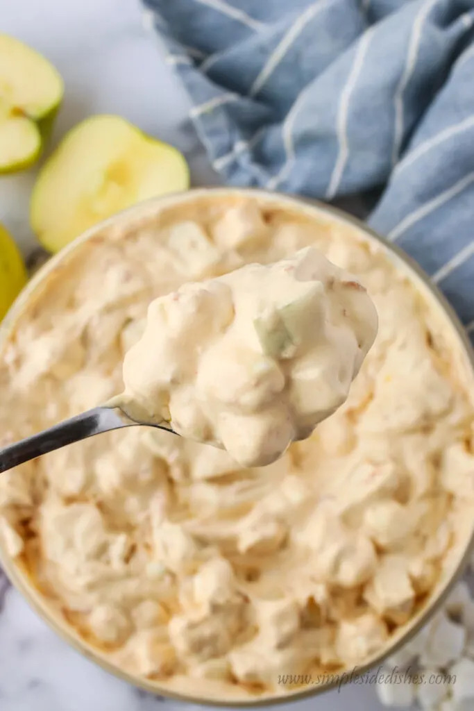 Bowl of caramel apple salad with a spoon scooping some out