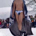 Male model strutting on a snow-covered catwalk, scantily dressed, at a fashion show in Kashmir, sparking controversy.