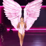 Gigi Hadid walks the runway for the Victoria's Secret Fashion Show 2024, wearing a satin pink bodysuit with crystal embellishments and large feathered wings