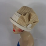 Woman wearing a vintage-style cloche hat with a decorative flower, exemplifying the timeless elegance of 1920s fashion.
