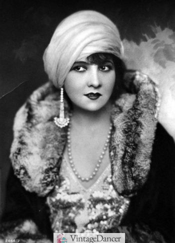 A 1920s actress wearing a turban hat, demonstrating its elegant and exotic style.